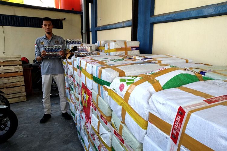 Petugas Kantor Bea Cukai Blitar menunjukkan rokok ilegal yang disita dari satu bus penumpang tujuan Sumatera, Kamis (25/7/2024)