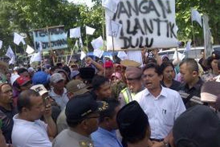 Demo pelantikan kades di Kabupaten Malang. Ratusan warga pendukung calon kalah memaksa untuk masukhalaman pendopo. Namun, tidak diperbolehkan polisi. Rabu (11/12/2013).