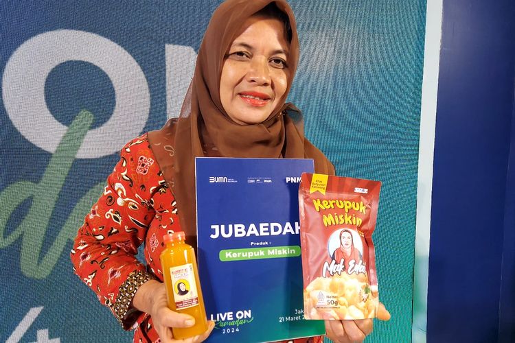Jubaedah memegang produk Kerupuk Miskin dan jamu di sela-sela acara buka bersama PNM, Kamis (21/3/2024)