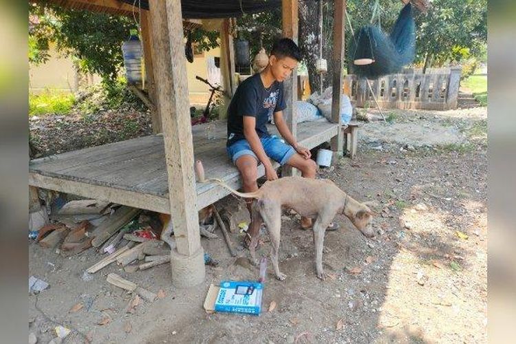Reihan Agustian saat bersama anjingnya di depan rumah di Madasari, Desa Masawah, Kecamatan Cimerak, Kabupaten