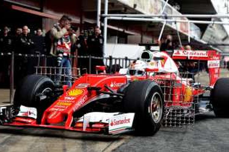 Pebalap Ferrari asal Jerman, Sebastian Vettel, menunggu di mobil saat tes pramusim Formula 1 2016 di Sirkuit de Barcelona-Catalunya, Senin (22/2/2016).