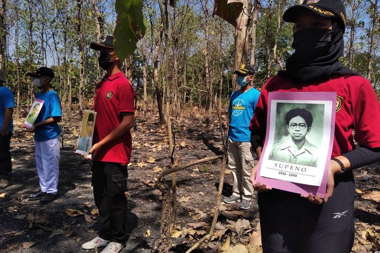 Salah satu peserta upacara bendera di tengah hutan Desa Ngadiboyo Nganjuk membawa foto Soepeno, Selasa (17/8/2021). Soepeno merupakan menteri yang gugur saat bergerilya melawan Belanda di Gunung Wilis wilayah Nganjuk