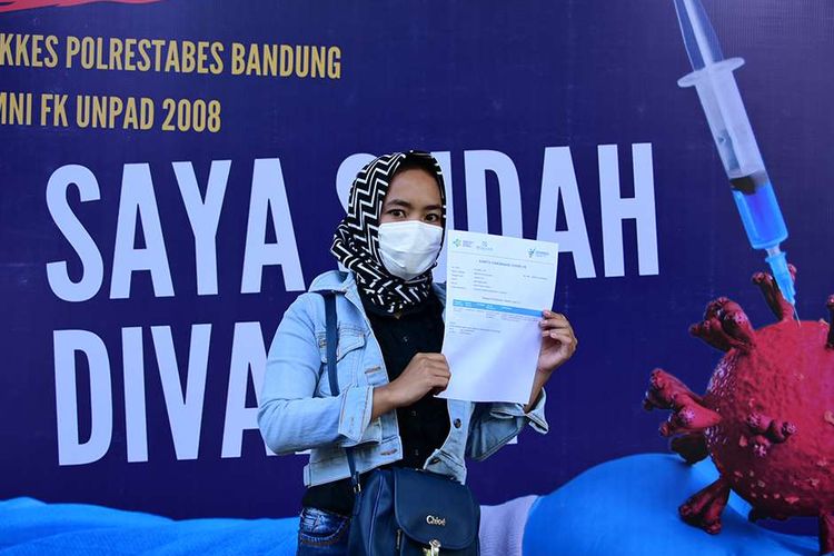 Warga berfoto usai menerima suntikan vaksin saat kegiatan vaksinasi Covid-19 massal di Gedung Graha Bhayangkara, Kota Bandung, Sabtu (26/6/2021). Di HUT Ke-75 Bhayangkara, Polrestabes Bandung menggelar pemberian vaksin Covid-19 di 11 titik di wilayah hukumnya dengan kuota sebanyak 14.983 orang.