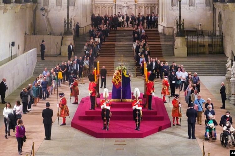 Warga Inggris memberikan penghormatan di sekitar peti mati Ratu Elizabeth II di Westminster Hall, London, 14 September 2022, di mana Ratu akan disemayamkan sebelum pemakamannya pada 19 September.