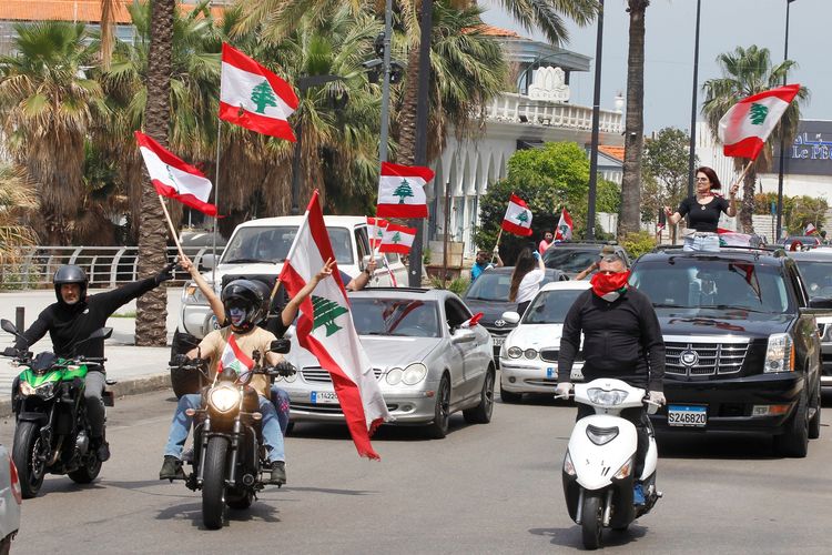Demonstrasi menentang pemerintahan yang korup dilakukan rakyat Lebanon menggunakan mobil pada Selasa (21/4/2020). Demonstran mengendarai mobil untuk mematuhi aturan social distancing demi mencegah penyebaran Covid-19.