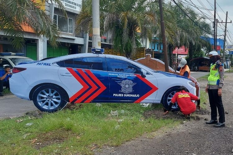 Petugas kepolisian memasang mobil patroli lalu lintas di Jalan Sukoharjo - Solo tepatnya depan Perumahan 3G Green Garden Sukoharjo, Jumat (24/12/2021).