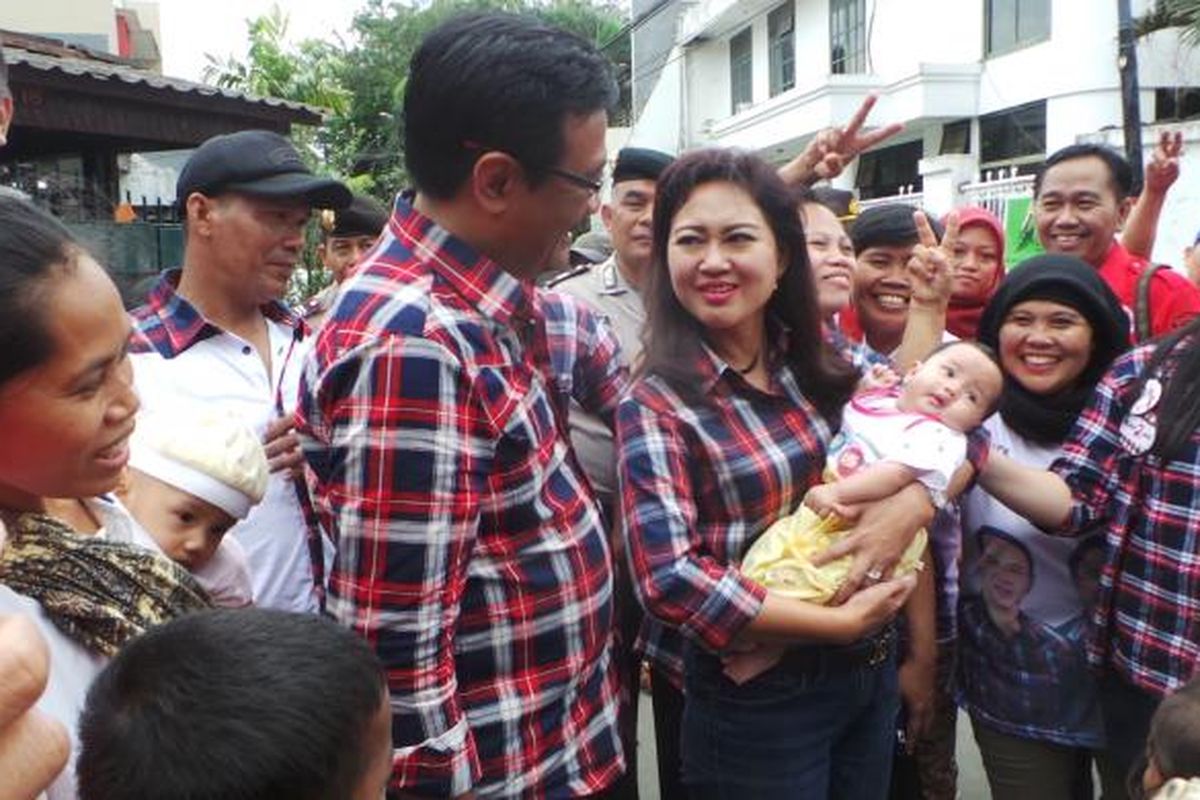Calon wakil gubernur DKI Jakarta Djarot Saiful Hidayat bersama istri, Happy Farida saat menggendong bayi warga, di Cidodol, Jakarta Selatan, Selasa (7/2/2017).