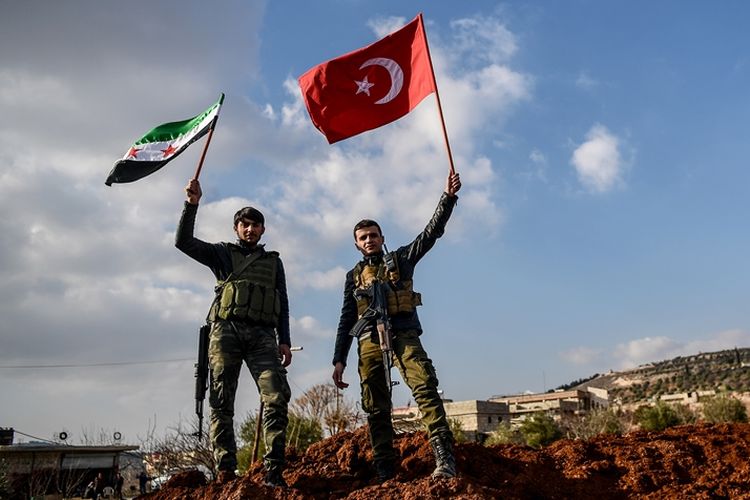 Tentara pemberontak Suriah yang didukung Turki memegang bendera Turki dan Pasukan Pembebas Suriah (FSA) di kota Azaz di dekat Afrin.