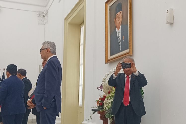 Menteri PUPR Basuki Hadimuljono saat memotret wartawan istana menggunakan smartphone barunya di Istana Bogor, Jawa Barat, Jumat (26/1/2024).