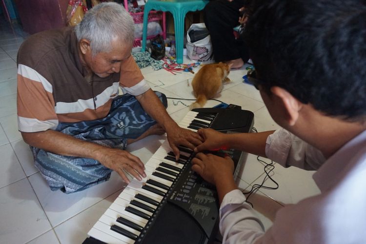 Mbah Jo sedang belajar bermain keyboard dengan Windoyo dari Yayasan Aura Lentera. 