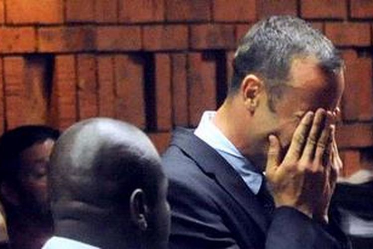 Pelari Oscar Pistorius, menutup wajahnya saat mendengarkan dakwaan di pengadilan Pretoria, Afrika Selatan, Selasa (19/2/2013). Jaksa mendakwa Pistorius melakukan pembunuhan berencana terhadap kekasihnya Reeva Steenkamp.
