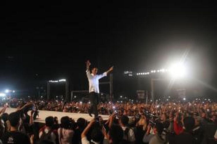 Presiden Joko Widodo atau dipanggil Jokowi menyapa ribuan warga di atas panggung pada acara Syukuran Rakyat Salam Tiga Jari di Monumen Nasional, Jakarta Pusat, Senin (20/10/2014). Syukuran diselenggarakan rakyat untuk menyambut presiden baru.   