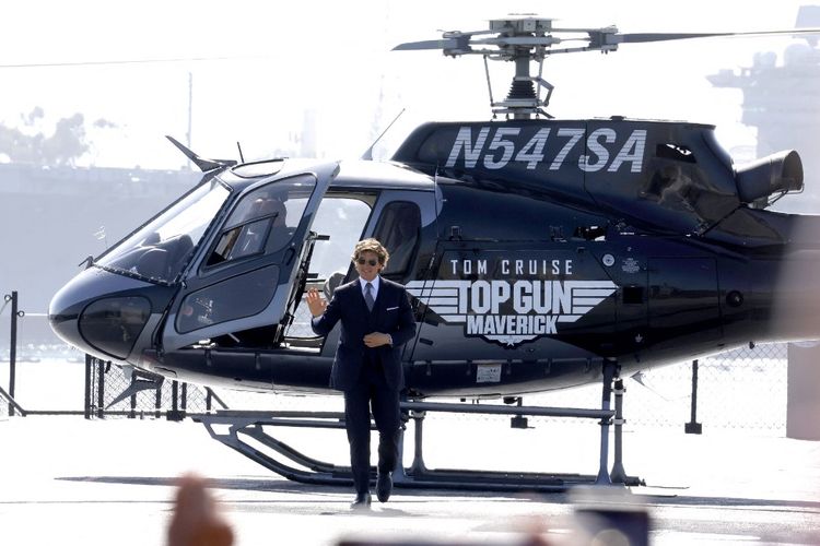 Aktor Tom Cruise turun dari helikopter yang dipilotinya sendiri untuk menghadiri pemutaran perdana film terbarunya Top Gun: Maverick yang dilakukan di USS Midway, San Diego, California, Rabu (4/5/2022).