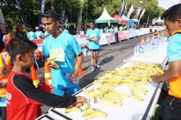 Peserta Banyuwangi Intetnasional Run 2016 menikmati pisang yang disedikan di garis finish Minggu (9/10/2016)