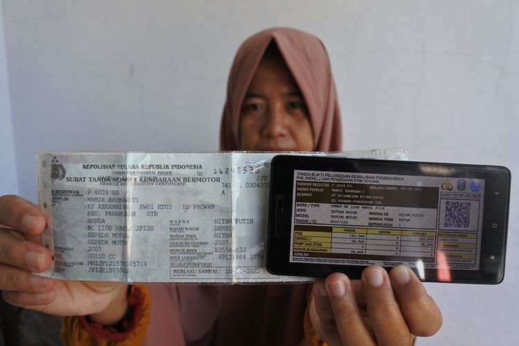 Seorang warga memperlihatkan bukti pelunasan pajak kendaraan bermotor yang dibayar secara daring atau online dari rumah di Panarukan, Situbondo, Jawa Timur, Kamis (26/3/2020). Pembayaran secara online itu karena diliburkannya pembayaran secara langsung melalui Samsat untuk mencegah penularan Covid-19.