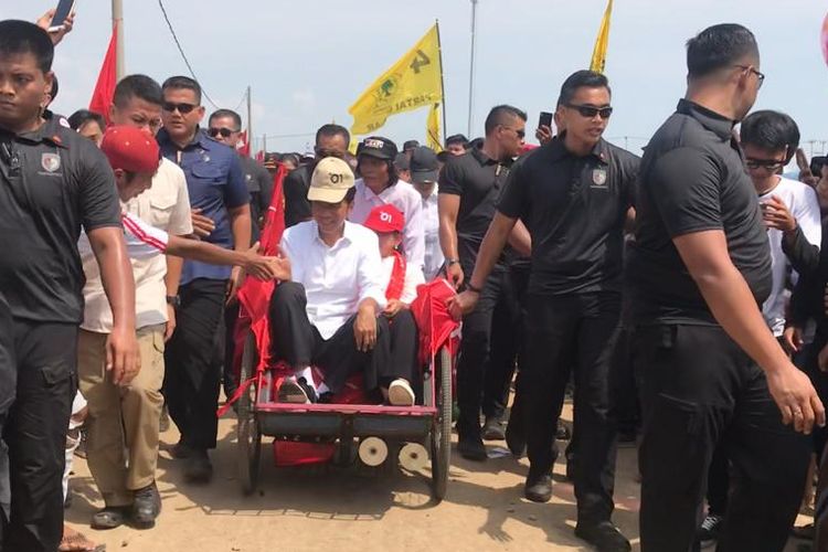 Capres petahana Joko Widodo beserta sang istri Iriana menaiki becak saat menghadiri kampanye terbuka di Pelabuhan Perikanan Gebang Mekar, Kabupaten Cirebon, Jawa Barat, Jumat (5/4/2019).