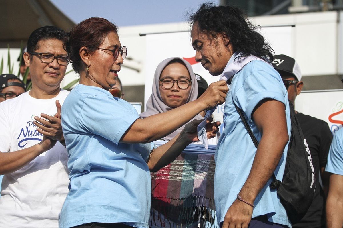 Menteri Kelautan dan Perikanan Susi Pudjiastuti menyematkan syal kepada musisi grup band Slank Kaka (kanan) saat meresmikan Pandu Laut Nusantara di kawasan Bundaran HI, Jakarta, Minggu (15/7/2018). 