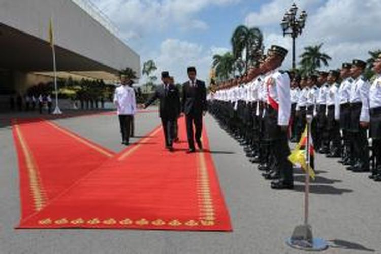 Presiden Joko Widodo didampingi Sultan Hassanal Bolkiah memeriksa barisan kehormatan setibanya di Bandar Seri Begawan, Sabtu (7/2/2015), dalam rangkaian lawatannya di Asia Tenggara.