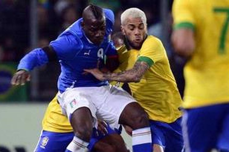 Bek Brasil, Daniel Alves (kanan), bertarung dengan penyerang Italia, Mario Balotelli, dalam laga uji coba di Stade de Geneve, Geneva, Swiss, Kamis (21/3/2013). 