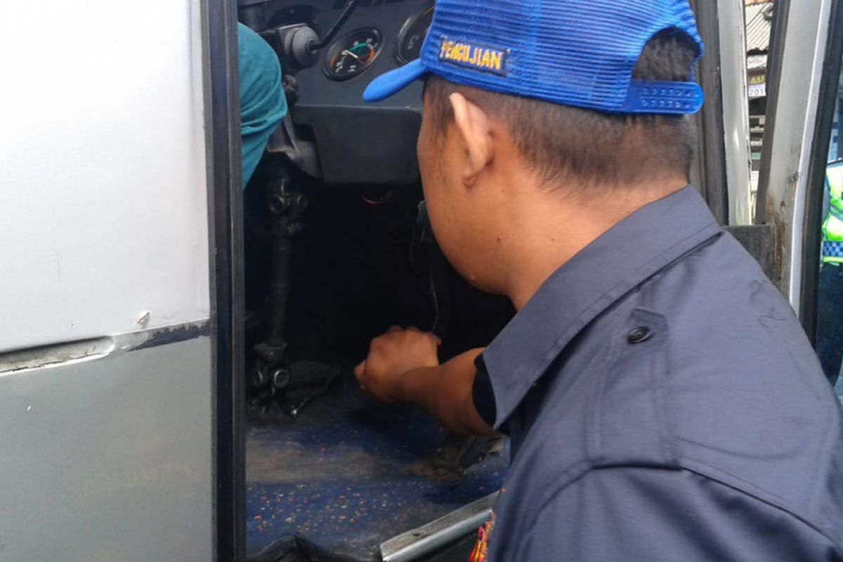 Petugas Dinas Perhubungan menekan pedal rem bus AKDP untuk mengecek kelayakan bus di Pangandaran, Kamis (20/12/2018).