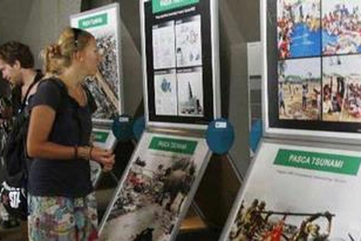 Wisatawan asing asal Swedia melihat foto-foto peristiwa tsunami 2004 lalu di Gedung Museum Tsunami, Banda Aceh, Jumat (6/5/2011).  