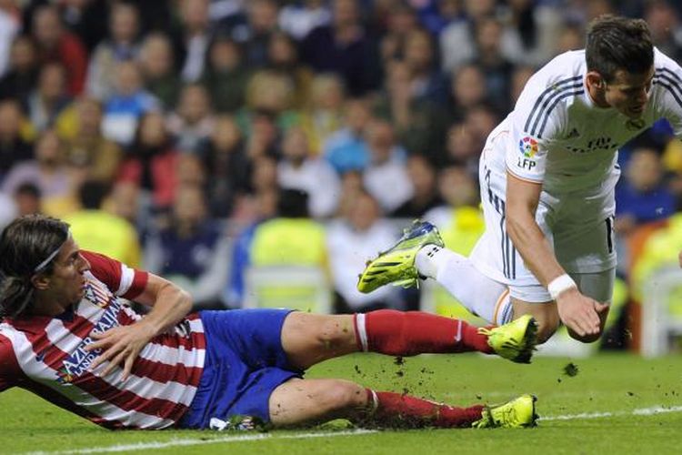 Winger Real Madrid asal Wales, Gareth Bale (kanan), berjibaku dengan bek Atletico Madrid asal Brasil, Filipe Luis, dalam derbi Madrid di Santiago Bernabeu, Sabtu (28/9/2013). Dalam laga ini Atletico menang 1-0 dan mereka untuk pertama kalinya menang di ajang La Liga di kandang Madrid setelah 14 tahun silam.