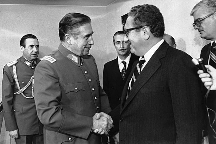 Diktator Chile yang didukung AS, Jenderal Augusto Pinochet (kiri), berjabat tangan dengan Henry Kissinger (kanan) pada 1976.
