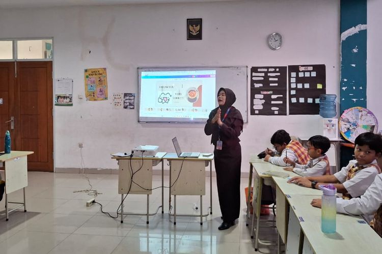 Rahayu Sulistyani yang merupakan seorang guru di Sekolah Dasar (SD) Bosowa Bina Insani, Bogor, Jawa Barat, terlihat sedang mengajar anak didiknya di kelas