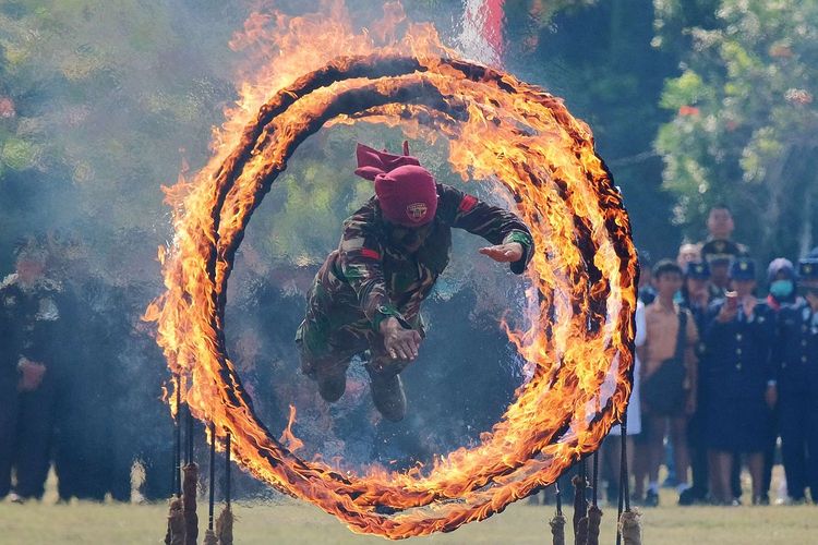 Prajurit TNI Kodam IX Udayana menerobos lingkaran api dalam atraksi halang rintang untuk memperingati HUT ke-74 TNI di Lapangan Puputan Margarana, Denpasar, Bali, Sabtu (5/10/2019). Atraksi tersebut diisi dengan spartan komando, simulasi halang rintang, bela diri militer dan keterampilan menghancurkan material guna meningkatkan kemampuan tempur para prajurit.