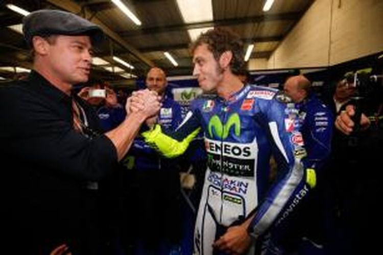 Bintang film Hollywood, Valentino Rossi, menyalami pebalap Movistar Yamaha asal Italia, Valentino Rossi, setelah balapan GP Inggris di Sirkuit Silverstone, Minggu (30/8/2015).