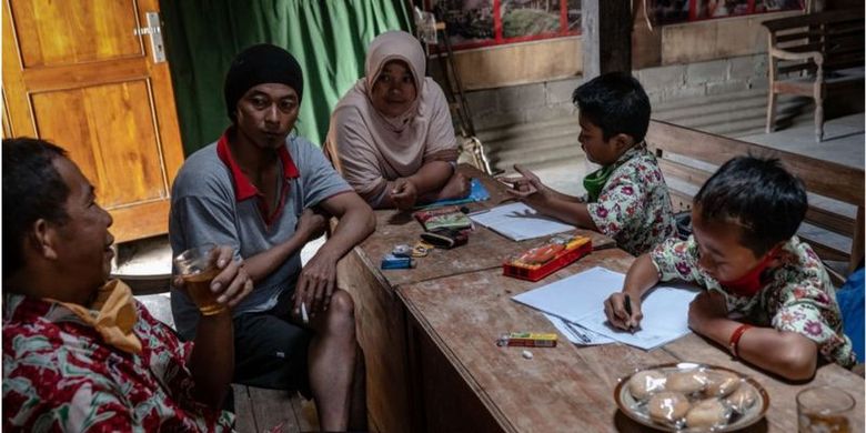 Parmin (kiri), seorang guru di kaki Gunung Merapi, Boyolali, Jawa Tengah mengunjungi dua siswanya saat pandemi Covid-19. Momen itu juga digunakannya untuk berdiskusi dengan orang tua siswa.