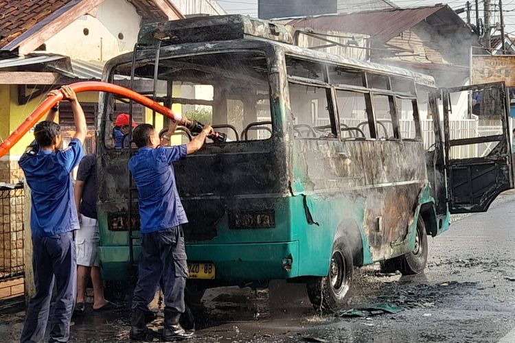 Petugas Damkar memadamkan api yang membakar mikrobus di Jalan dr Sutomo Majenang, Kabupaten Cilacap, Jawa Tengah, Selasa (2/5/2023) pagi.