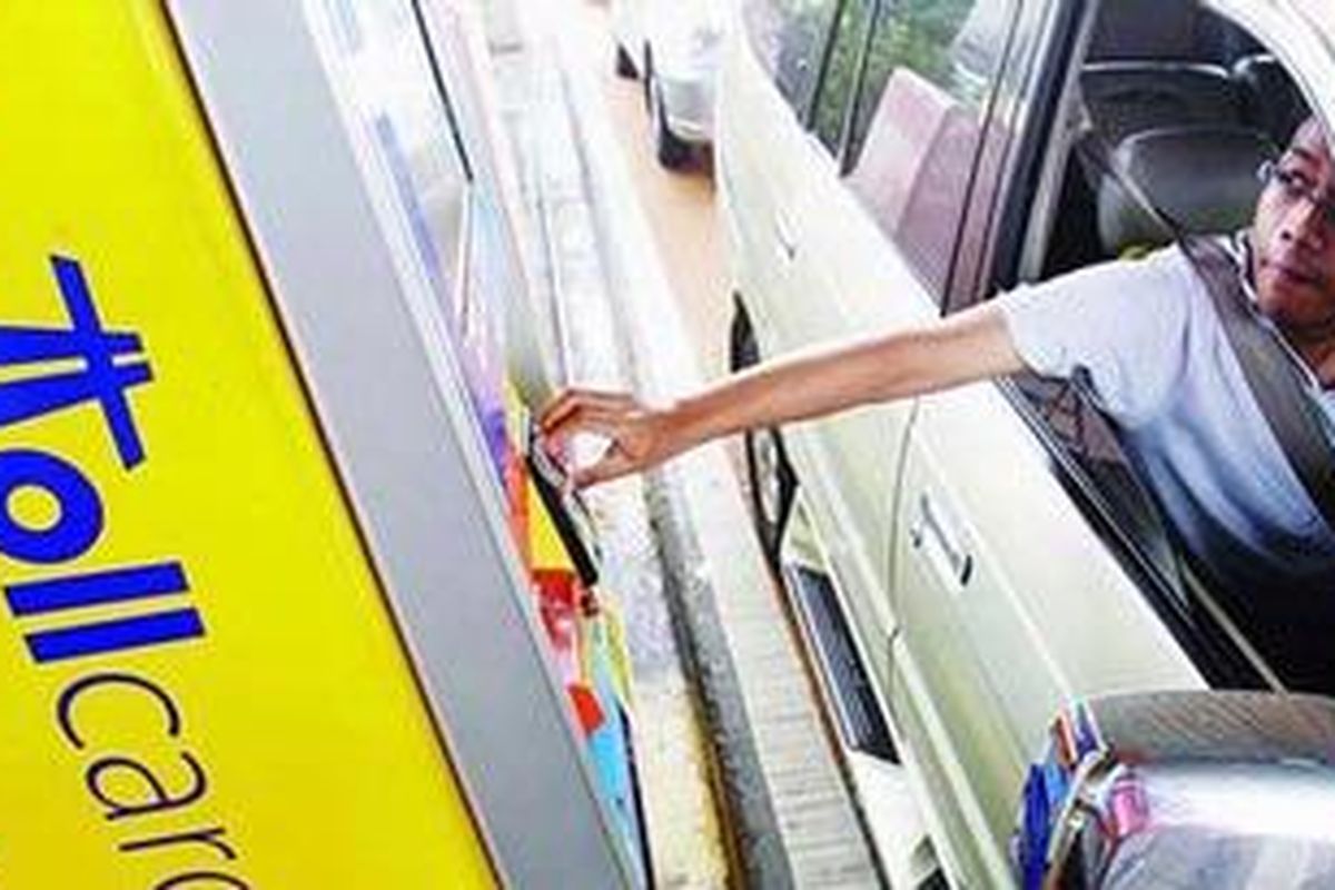 Pengguna jalan tol membayar dengankartu e-toll card di gardu tol otomatis di pintu Tol Cililitan, Jakarta, Senin (16/11/2009). Penggunaan pintu tol tersebut bertujuan mempersingkat transaksi pembayaran dan meminimalkan penggunaan uang kartal. 