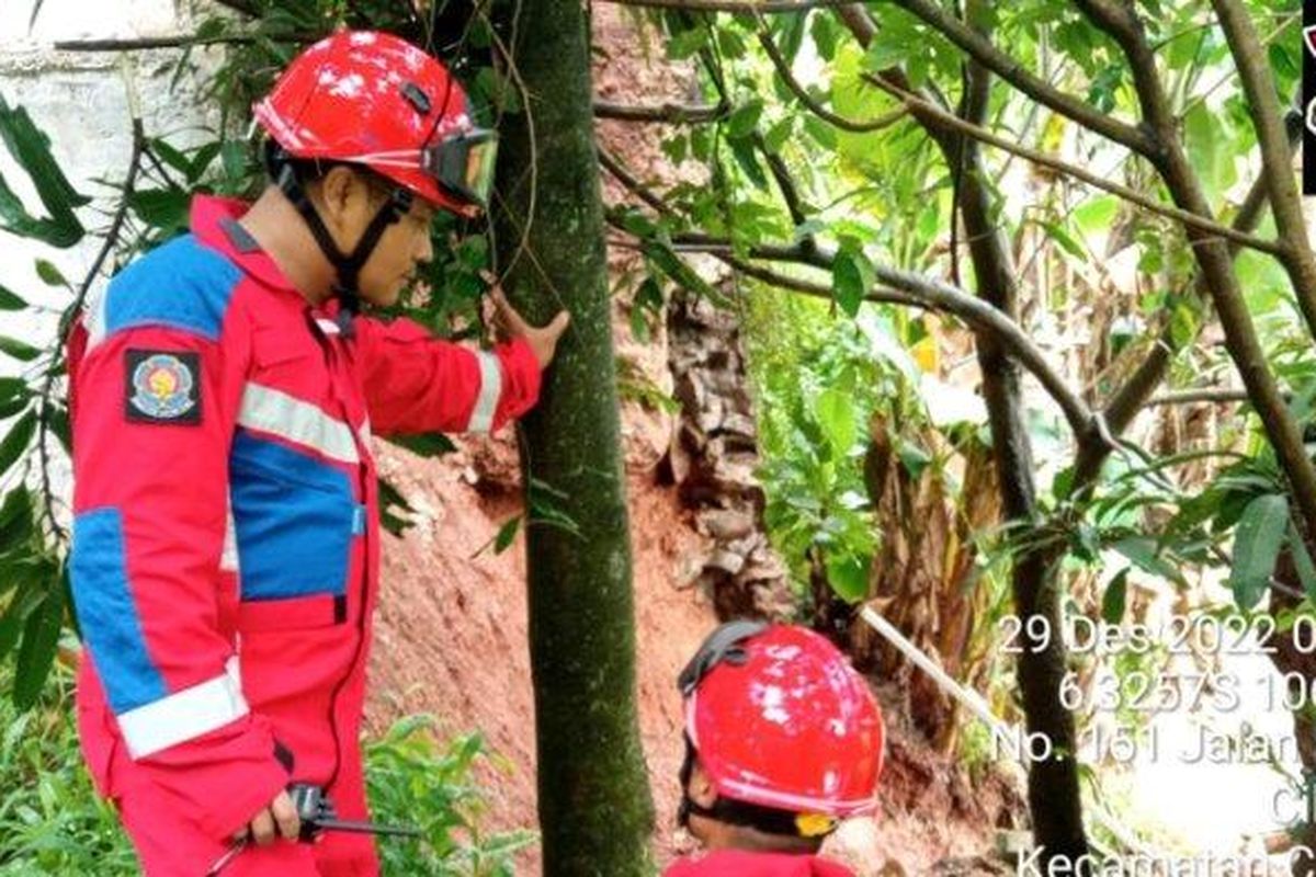 Personel Damkar Jakarta Timur saat melakukan pemeriksaan lokasi turap Kali Cilangkap yang longsor, Cipayung, Kamis (29/12/2022)