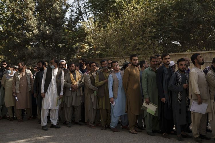 Warga Afghanistan berbaris di luar kantor paspor pemerintah yang baru mengumumkan akan dibuka kembali setelah Taliban mengumumkan mereka akan mengeluarkan simpanan  aplikasi yang disetujui oleh pemerintahan sebelumnya di Kabul, Afghanistan, Rabu, 6 Oktober 2021.