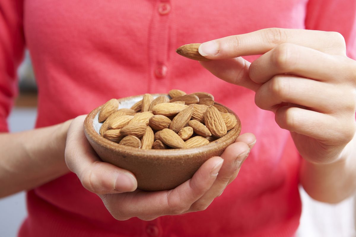 Ilustrasi makan kacang almond untuk kulit wajah.