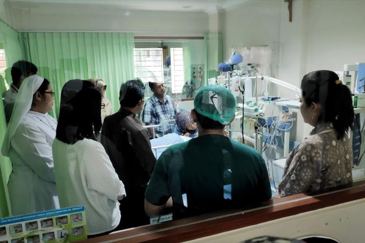 Kepala Dinas Pendidikan Sumsel Widodo bersama istri Gubernur Sumsel Feby Deru saat membesuk WJ (14) korban kekerasan orientasi di SMA Taruna Indonesia ketika di rawat di RS RK Charitas Palembang, Rabu (17/7/2019).