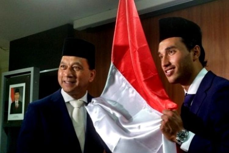 Striker timnas Indonesia, Ezra Walian (kanan) dan ayahnya Gleen Walian (kiri), memegang bendera merah putih selepas disumpah menjadi WNI di Kanwil Kemkumham, Cawang, Jakarta Timur, Kamis (18/5/2017).