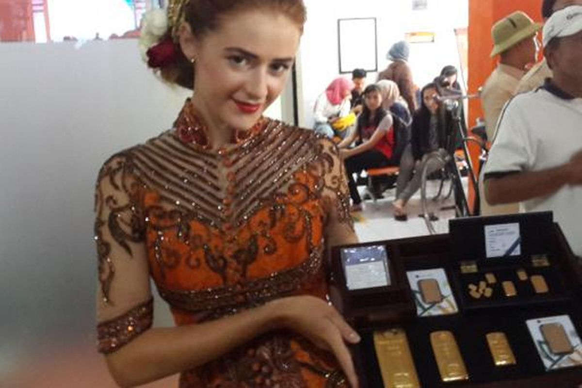 Seorang model saat menampilkan model emas batangan dalam grand launching kerja sama antara PT Pos Indonesia dan PT Antam di Kantor Pos Malang, Senin (6/2/2017)