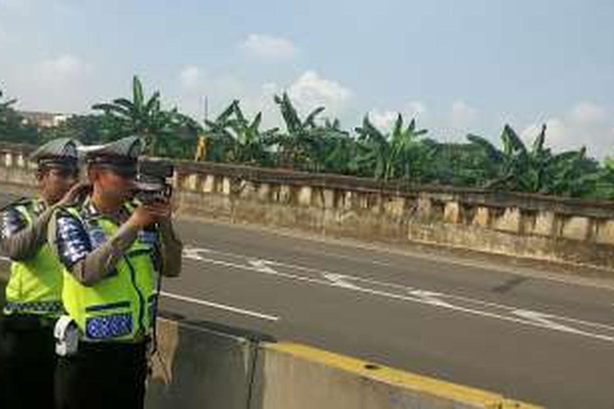 Petugas kepolisian dari Direktorat Lalu Lintas Polda Metro Jaya melakukan uji coba pembatasan kecepatan dengan menggunakan Speed Gun di tol yang mengarah ke bandara pada KM 25-900, Jakarta, Sabtu (12/3/2016).