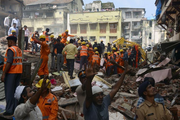 Petugas penyelamat dan warga mencari korban selamat di lokasi keruntuhan bangunan di Mumbai, Kamis (31/8/2017).    