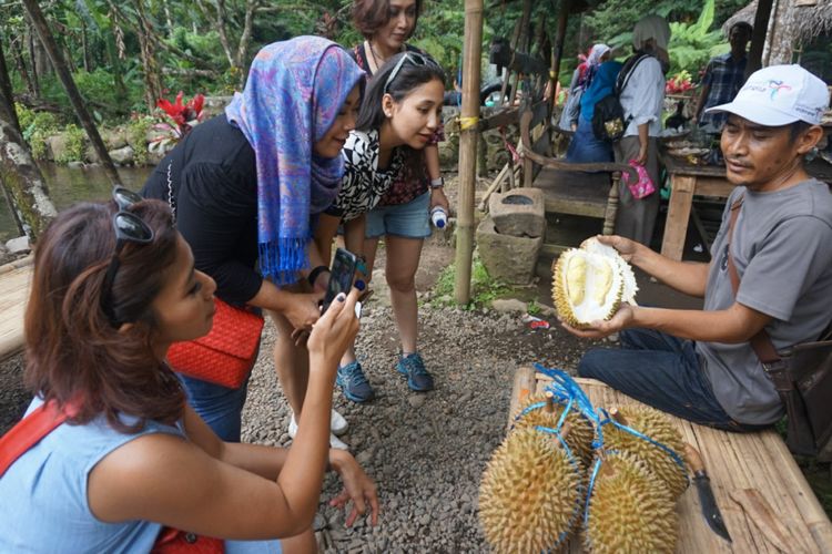 Pak Likin sedang menunjukkan durian kepada wisatawan yang datang ke kebunnya di Songgon Banyuwangi, Jawa Timur, Minggu (18/2/2018).