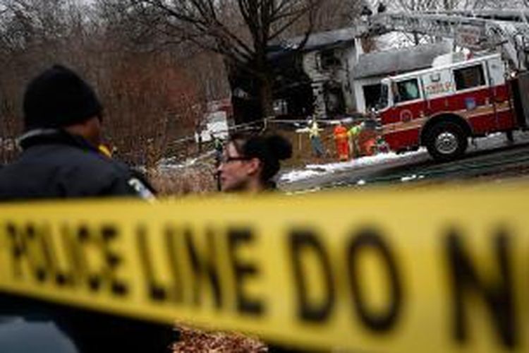 Petugas layanan darurat sedang bekeja di lokasi jatuhnya pesawat jet kecil di kawasan permukiman di Gaithersburg, Maryland, Amerika Serikat, Senin (8/12/2014). Tiga orang dilaporkan tewas dalam kecelakaan ini, dengan satu rumah warga terbakar dan dua lainnya rusak.
