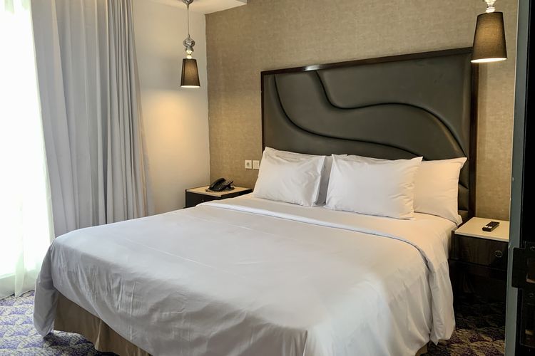Ruang tidur Suite Room Fairview Hotel by Artotel, Jakarta Selatan, menghadap perkotaan.