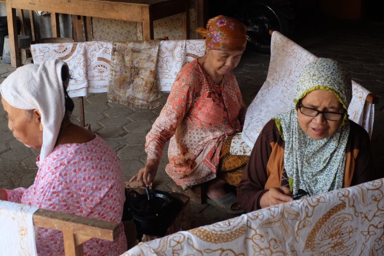 Penduduk Desa Giriloyo membatik di teras rumah.