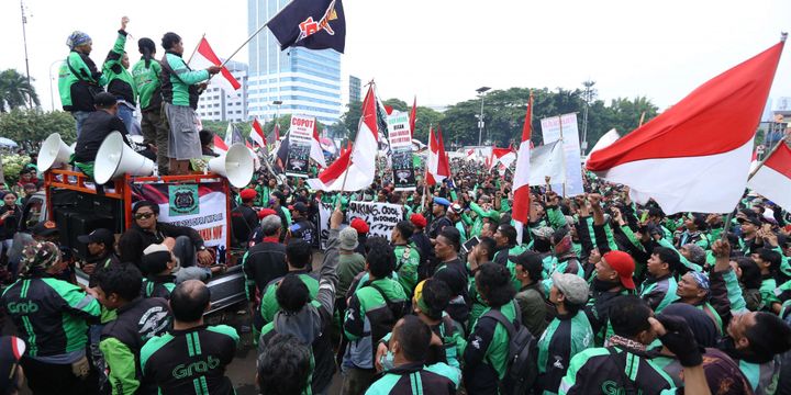 Sejumlah massa ojek online berunjuk rasa saat demo di depan Gedung DPR/MPR RI untuk berunjuk rasa menyampaikan aspirasinya, Senin (23/4/2018). Dalam demo ini para  pengemudi ojek online menuntut kenaikan tarif, Pengakuan legal, dan perlindungan hukum dan keadilan bagi ojek online.