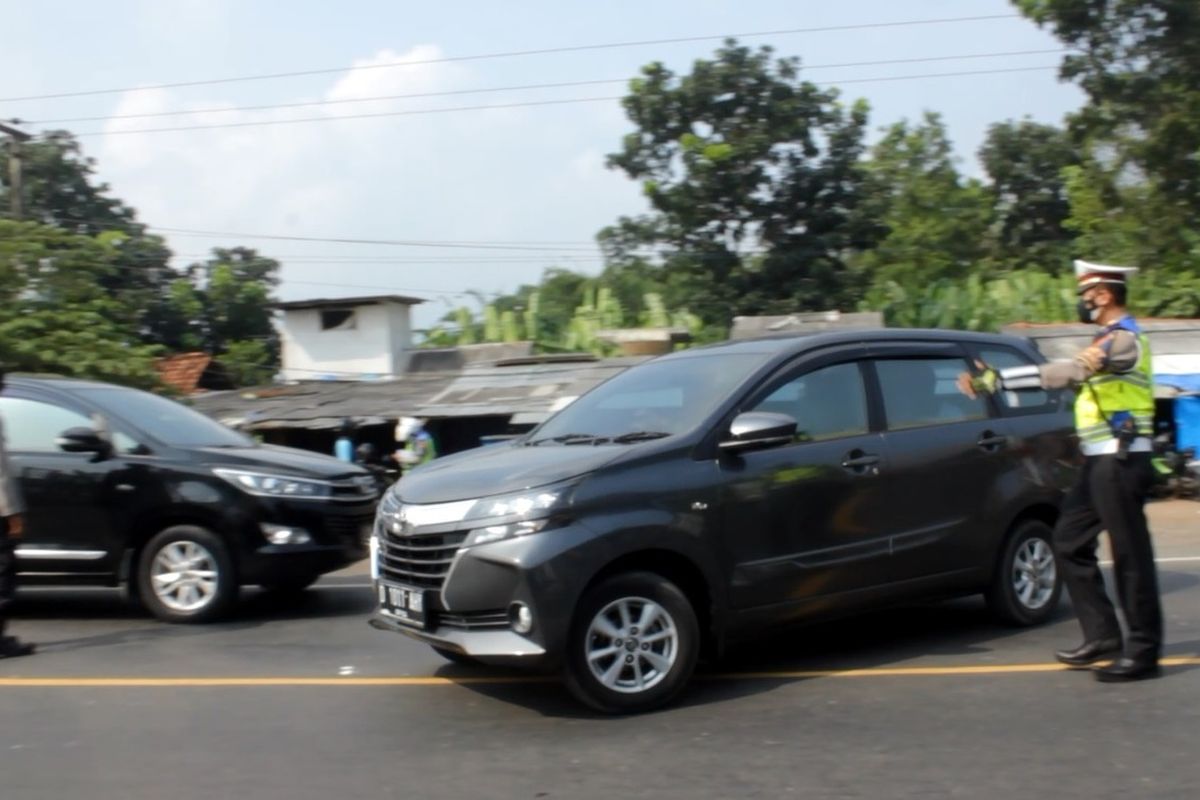 Petugas memutar balik kendaraan yang hendak menuju Cianjur di kawasan Jembatan Citarum yang merupakan wilayah perbatasan antara Cianjur dan Bandung Barat, Kamis (6/5/2021). Para pengendara yang tidak membawa surat keterangan bebas Covid-19 langsung diputar balik.