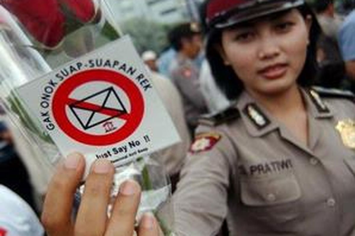 Anggota Samapta Powiltabes Surabaya menunjukkan bunga dan stiker ajakan menolak suap di sela-sela mengamankan unjuk rasa peringatan Hari Antikorupsi Sedunia di Surabaya, Rabu (9/12/2009). Unjuk rasa diikuti ratusan orang dari berbagai elemen. 