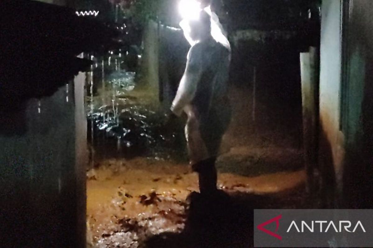 Seseorang berdiri di dekat lokasi banjir di Kecamatan Cugenang, Kabupaten Cianjur, Jawa Barat akibat hujan deras, Senin (20/3/2023). 