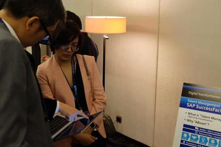 Peserta Digital Transformation Day 2019 Indonesia sedang mendengarkan penjelasan di booth exhibition mengenai penerapan aplikasi digital dalam bisnis. 